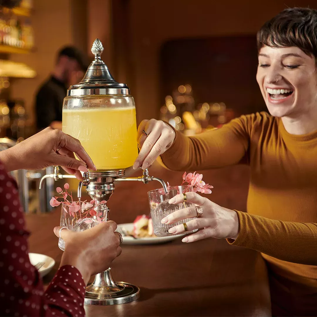 A group of friend eating and drinking cocktails